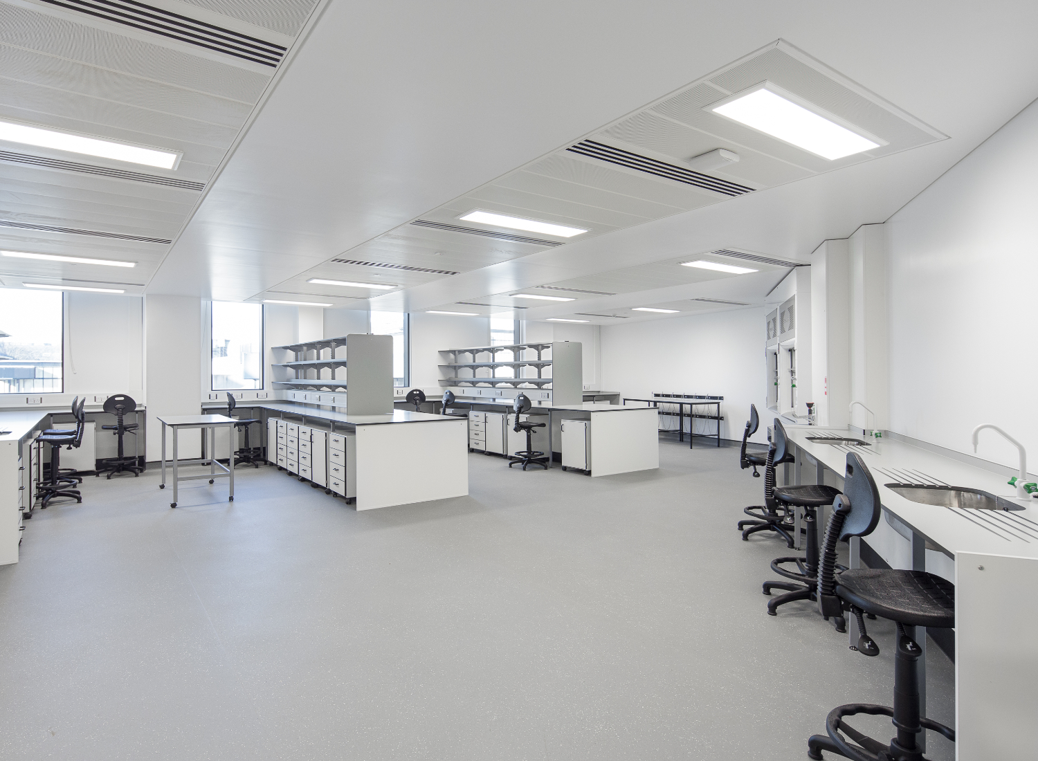A view of a lab in Nexus. The image show 3 large benches and a fume cupboard