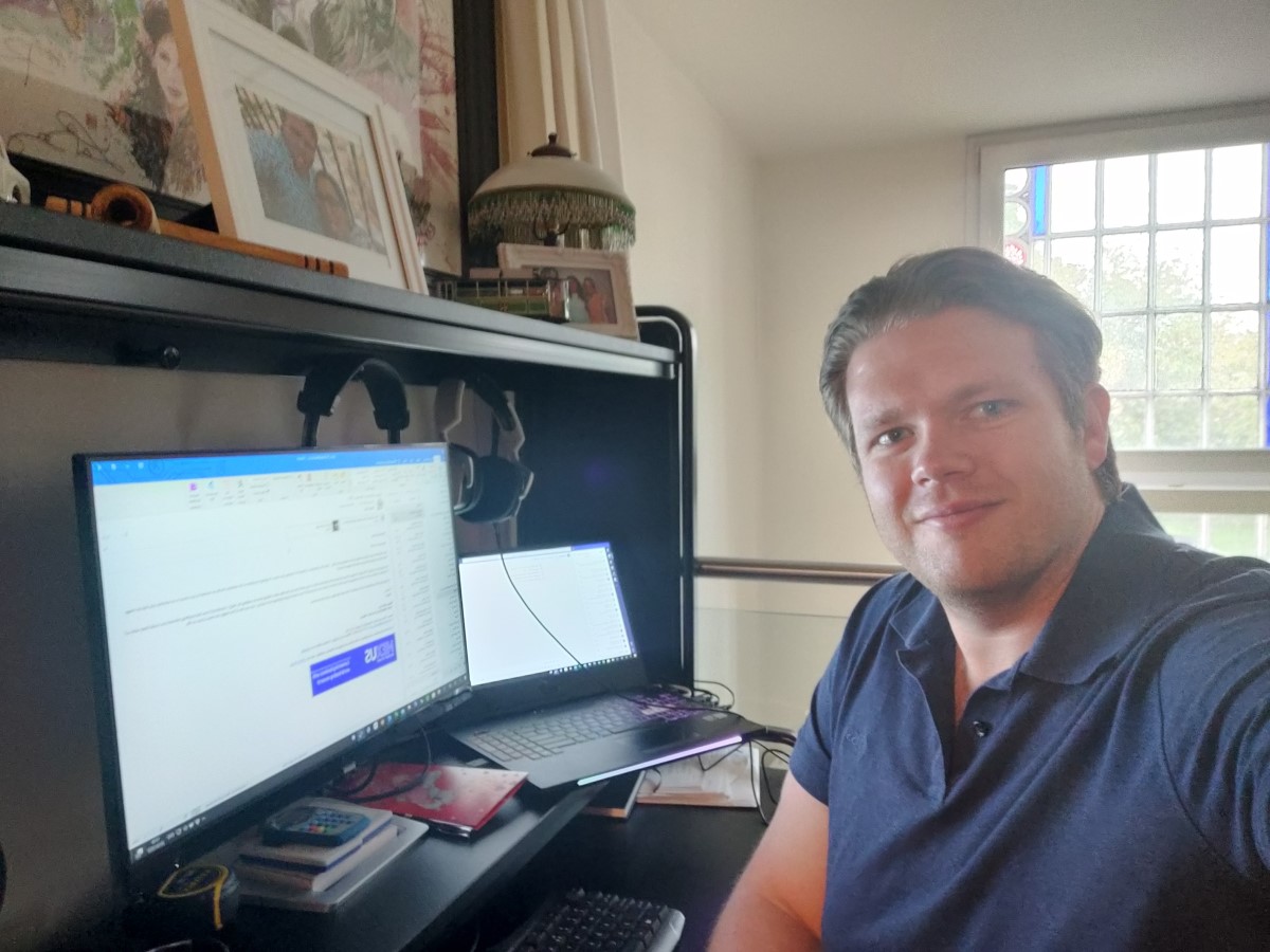 Image of Dennis Dokter sat in front of his computer in his home office