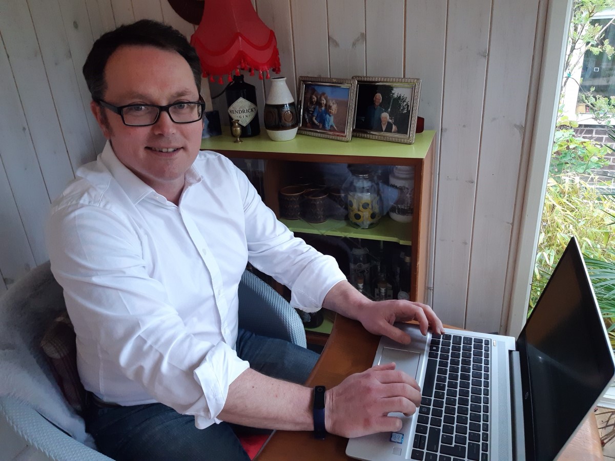 Mark Tock sitting in front of his laptop in his remote working environment