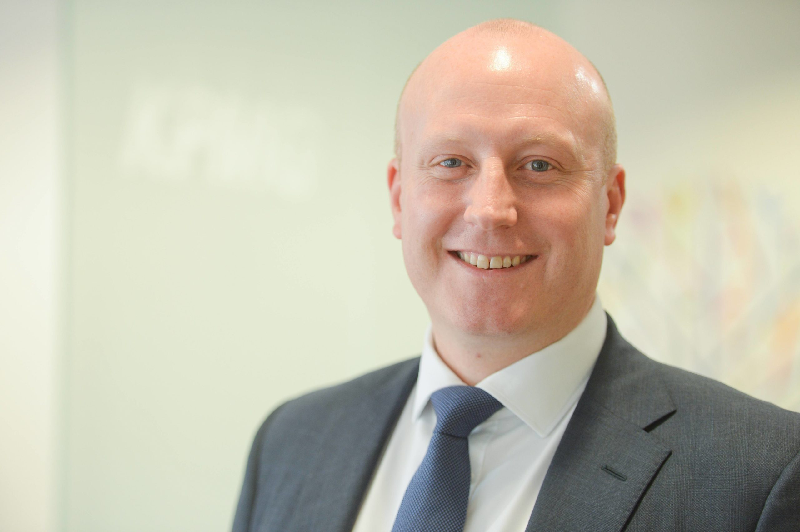 Head and shoulders shot of Euan West, Office Senior Partner at KPMG smiling to camera