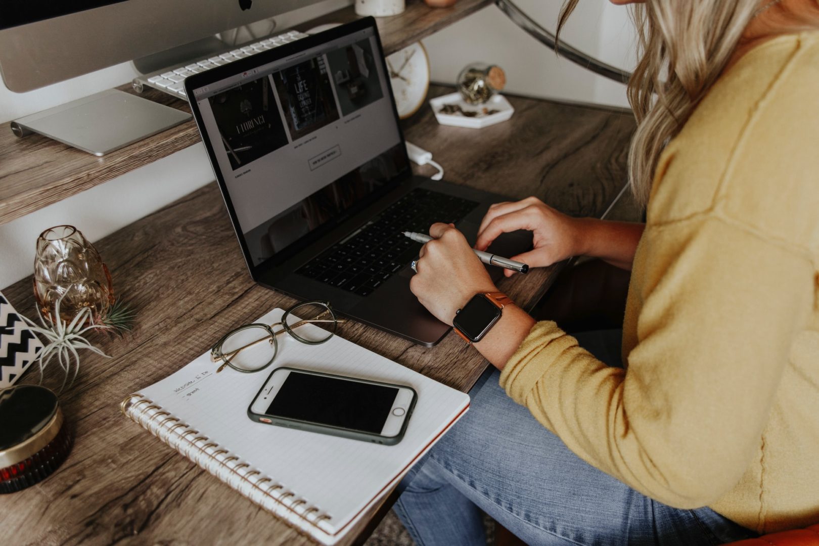 Image of woman sat at desk working on a laptop in a home office environment