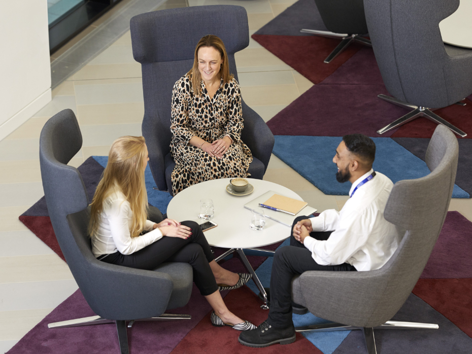 Three people sat around a table in Nexus in discussion.