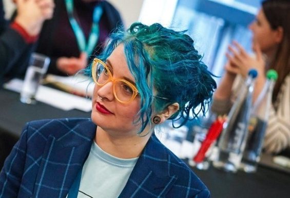 Jem Henderson, sat at table during event and looking away from camera