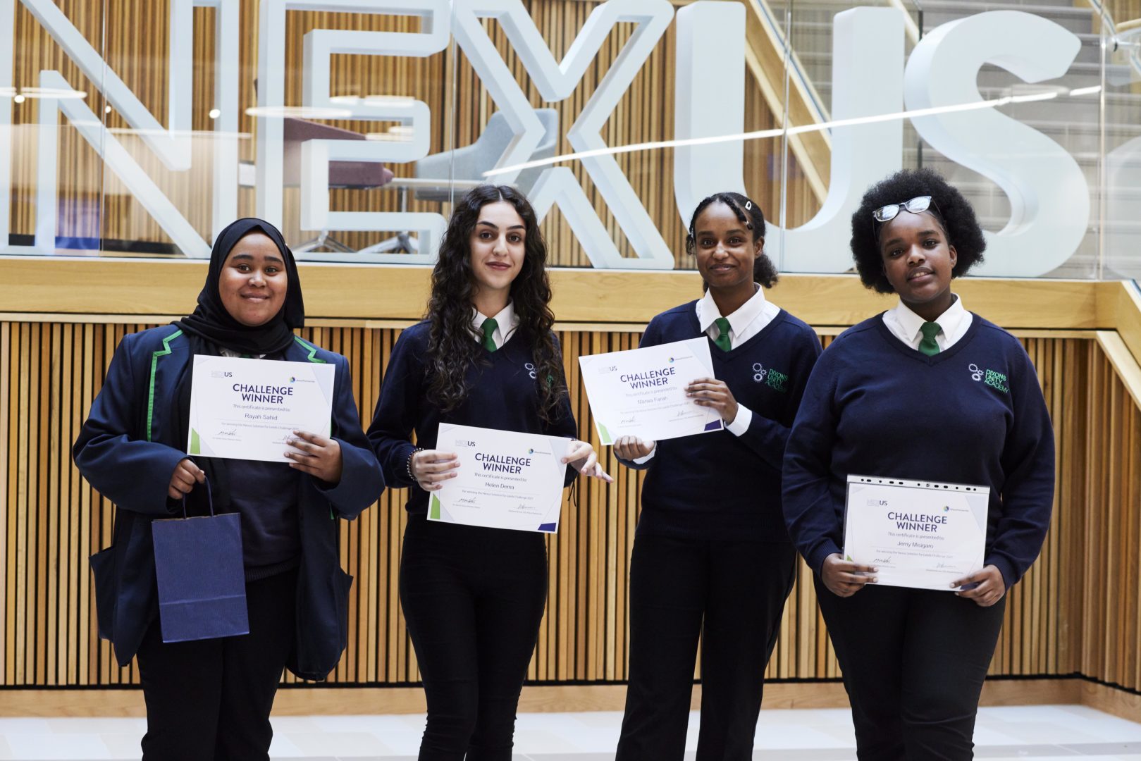 Four students from the winning team of Solution from Leeds standing in front of the Nexus logo