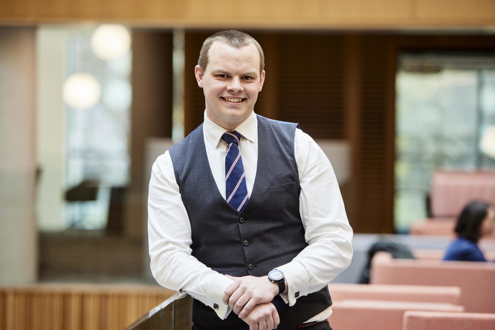 Nathan Berry, Head of Collaboration at Nexus standing in the building's atrium and smiling to camera
