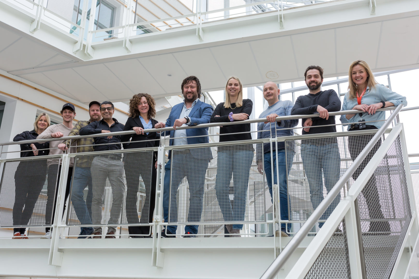 Image of Ledidi team standing on balcony inside office building