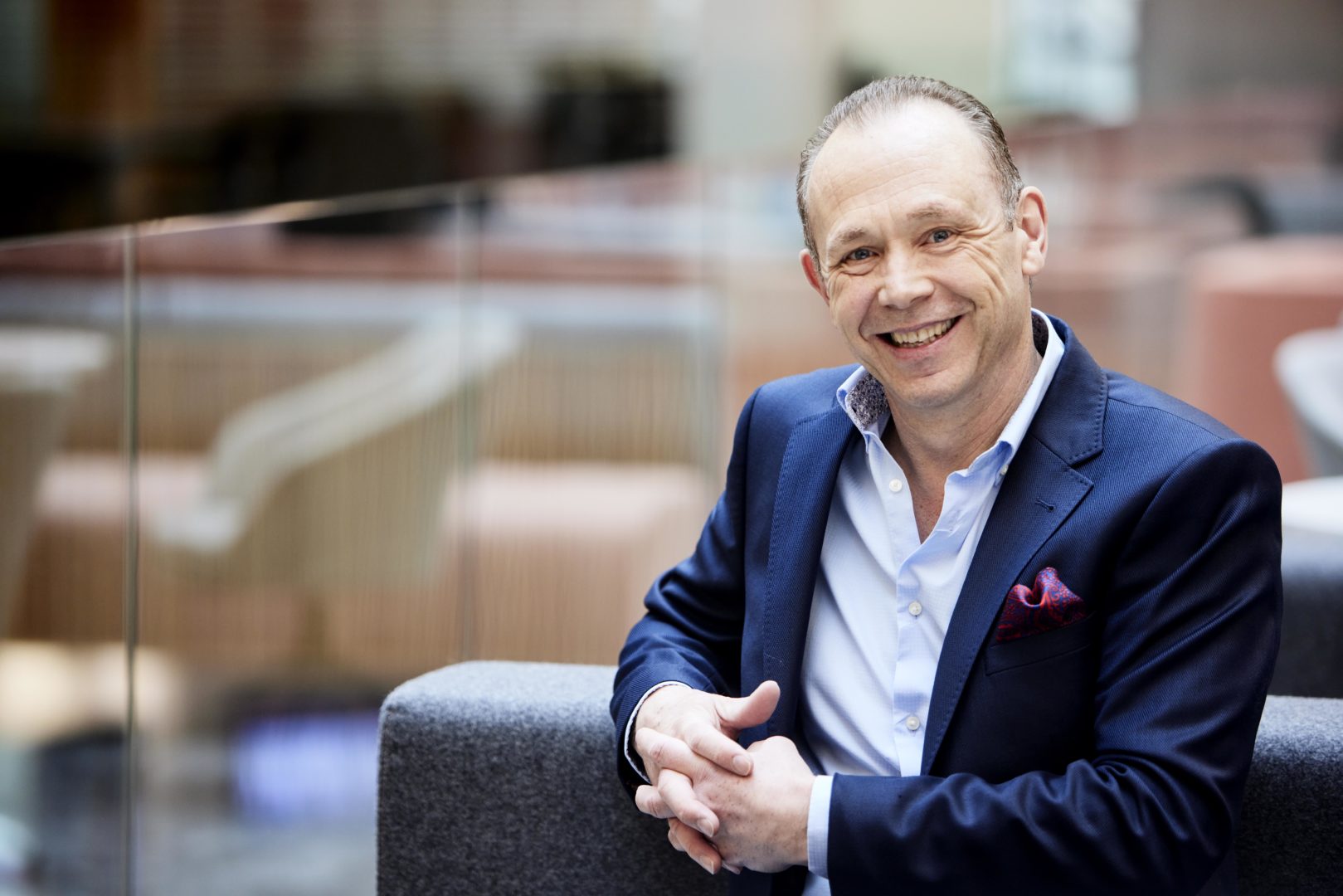 Martin Stow, Nexus Director sat on a sofa, casually leaning and smiling to camera