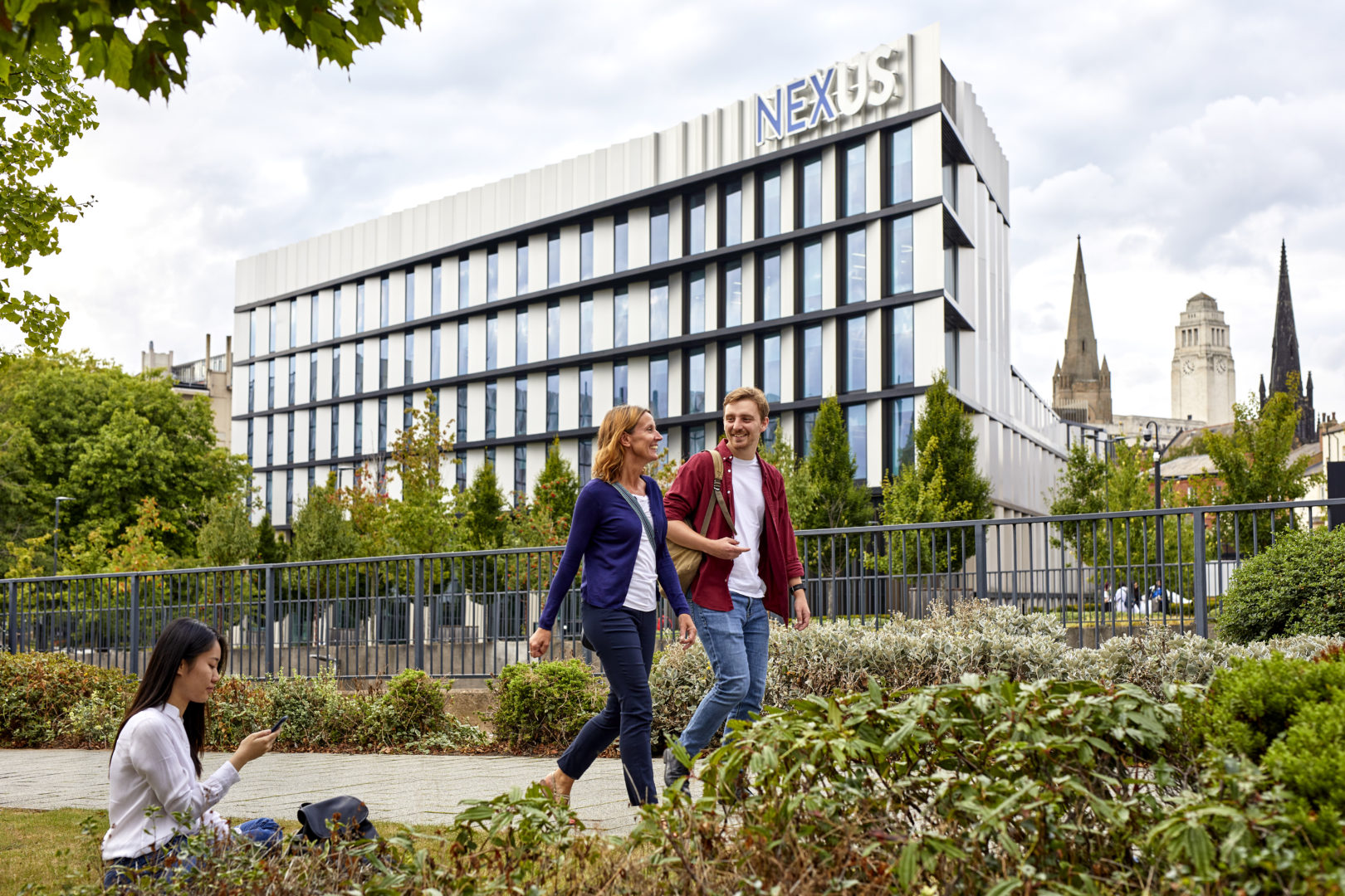 2 colleagues walking happily outside of the Nexus building.