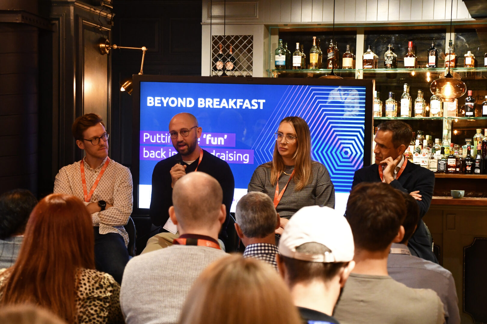 A panel of four people speaking at an event.