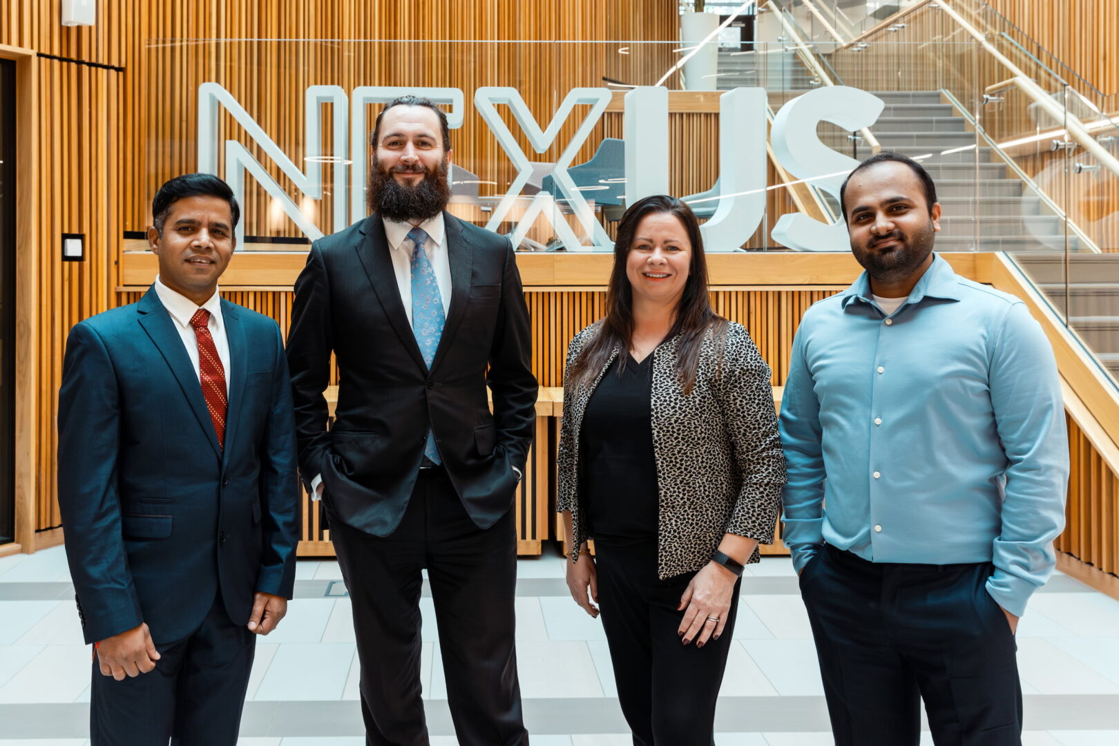 Photograph of the CGFI team smiling to camera infront of the Nexus logo.
