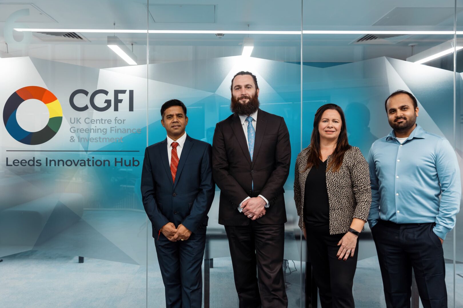 Photograph of the CGFI team located Nexus stood next to their company logo.